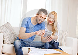 Smiling couple with papers and calculator at home