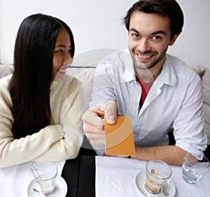 Smiling couple paying for meal at restaurant