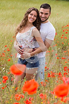 Smiling couple in poppies plants