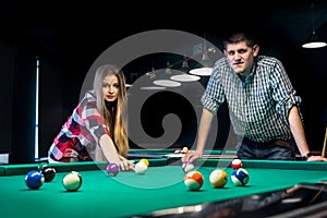 Smiling couple in pub playing billiard