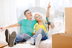 Smiling couple relaxing on sofa in new home