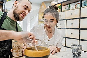 Smiling couple of sculptors in aprons photo