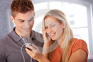 Smiling couple sharing earphones