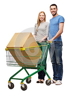 Smiling couple with shopping cart and big box