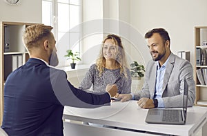 Smiling couple sing deal with realtor at meeting