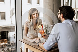 Smiling couple sitting on wood table and look at each other