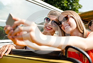 Smiling couple with smartphone making selfie