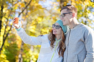 Smiling couple with smartphone taking selfie