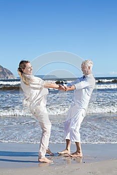 Smiling couple spinning on the beach