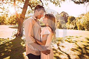 Smiling couple standing and embracing in park