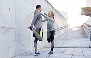 Smiling couple stretching leg outdoors