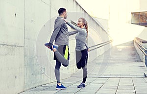 Smiling couple stretching leg outdoors