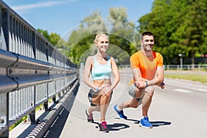 Smiling couple stretching leg outdoors