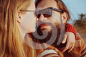 Smiling couple in sunglasses hugging and having fun outdoors in