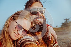 Smiling couple in sunglasses hugging and having fun outdoors in