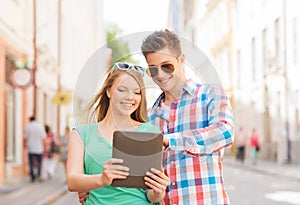 Smiling couple with tablet pc in city