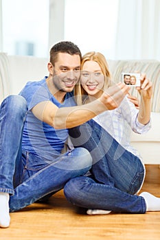 Smiling couple taking picture with digital camera