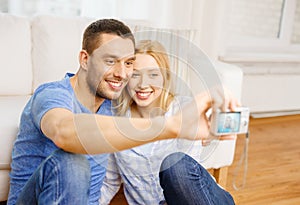 Smiling couple taking picture with digital camera