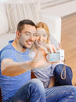 Smiling couple taking picture with digital camera