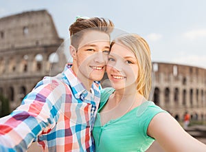 Smiling couple taking selfie over coliseum