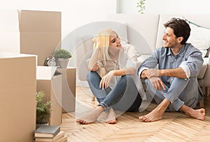 Smiling Couple Talking Sitting On Floor Moving Into New Apartment