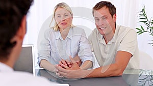 Smiling couple talking with their doctor
