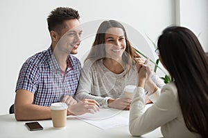 Smiling couple talking to real estate agent