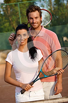 Smiling couple on tennis court
