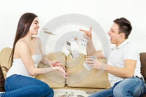 Smiling couple throwing cards at each other