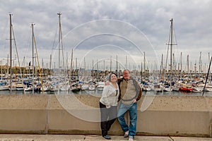 Smiling couple of tourists standing on promenade of Puerto Vell