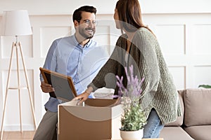 Smiling couple unpack packages moving in together