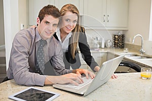 Smiling couple using laptop