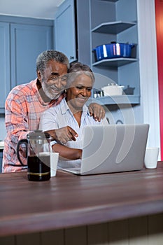 Smiling couple using laptop