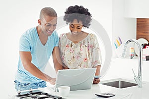 Smiling couple using laptop together