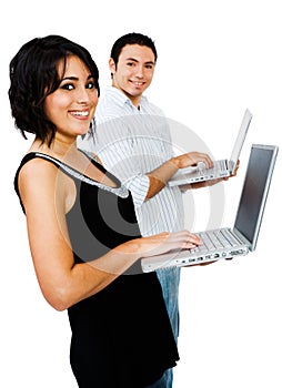 Smiling couple using laptops