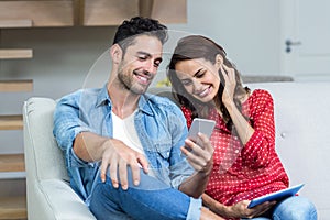 Smiling couple using phone