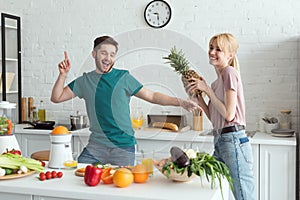 smiling couple of vegans having fun while cooking