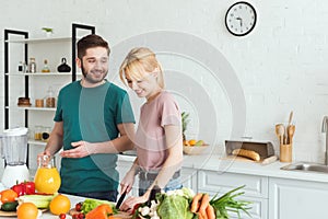 smiling couple of vegans preparing food