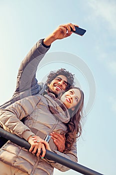 Smiling Couple will making a selfie embraced photo