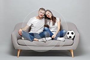 Smiling couple woman man football fans in white t-shirt cheer up support favorite team with soccer ball, hugging