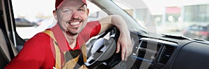 Smiling courier with clipboard on the driver seat of car