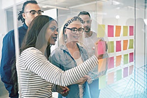 Smiling coworkers brainstorming with sticky notes in an office