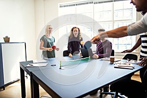 Smiling coworkers playing table tennis during a break from work