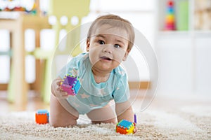 Smiling crawling baby boy on living room floor, caucasian child