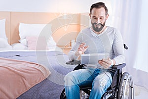 Smiling crippled man using a tablet