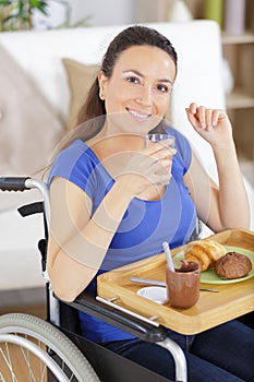 smiling crippled woman having breakfast at home