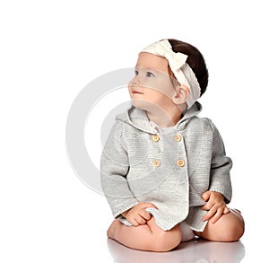 Smiling curious baby in knitted wear on floor