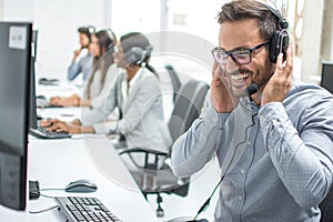 Smiling customer service executive with headset working in call center