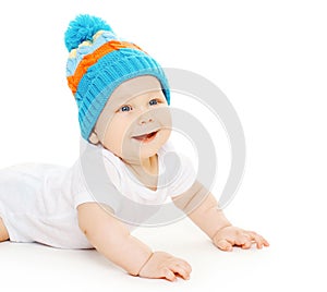 Smiling cute baby crawls in knitted hat