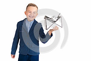 Smiling and cute with a blue jacket caucasian young boy holds gift box present for christmas.The boy closed his eyes